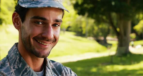 Portrait of smiling soldier in park alt