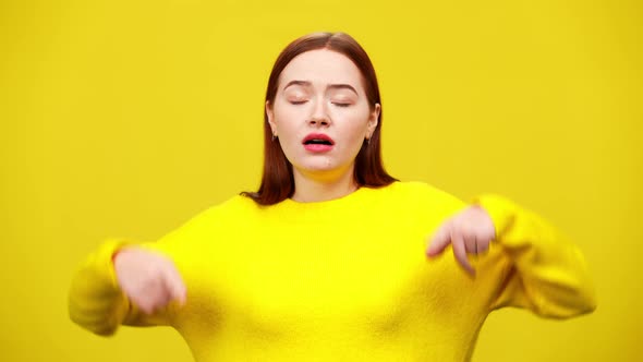 Stressed Young Redhead Woman Sighing and Closing Ears with Hands at Yellow Background