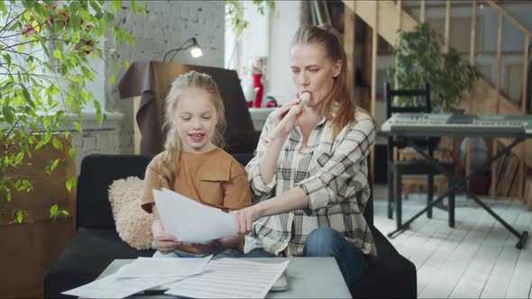 Mom and Daughter are Learning to Play the Flute By Notes and Sing