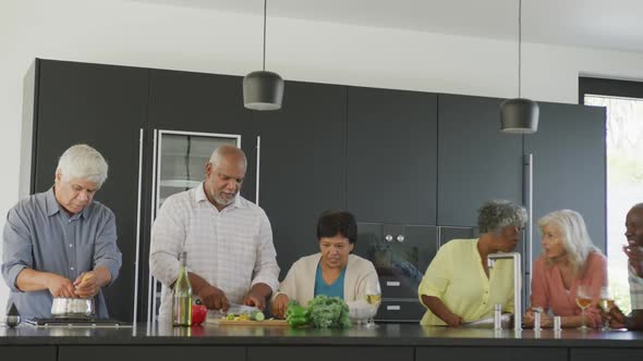 Happy senior diverse people cooking in kitchen at retirement home