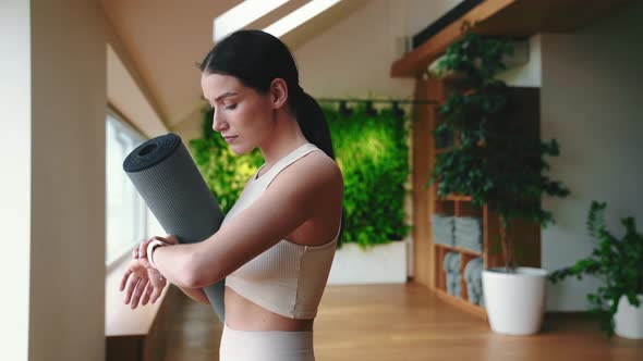 Pretty sporty brunette woman looking at smartwatch