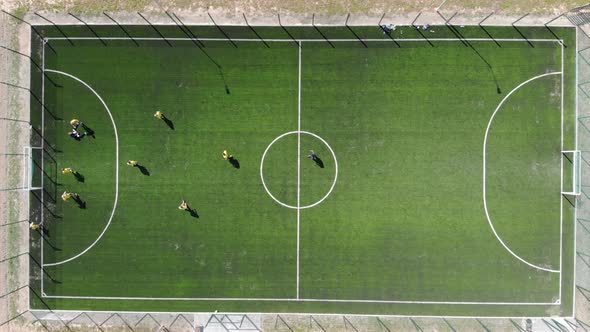 Aerial View of a Soccer Game Being Played at Nighttime with Floodlights Lighting the Field.