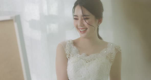 Slow Motion Beautiful Young Asian Bride Fitting Wedding Dress Front Of The Mirror. Bridal concept.