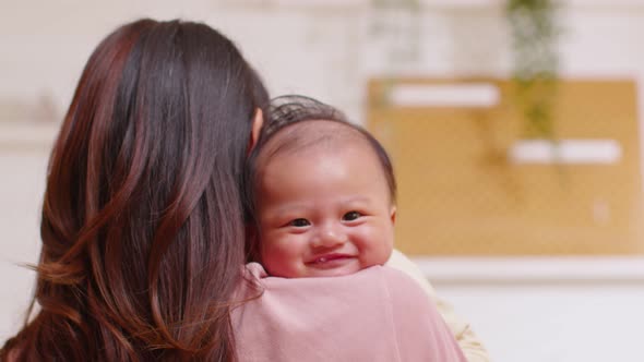 Close up face of adorable newborn baby smile and laughing in mother arm safety and comfortable