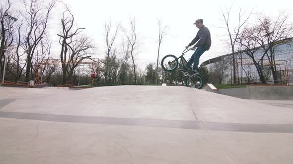 BMX Rider Doing Tricks in Cocncrete Skatepark