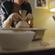 Young Female Potter Pulls the Neck of an Earthenware Vessel on Potter's Wheel - VideoHive Item for Sale