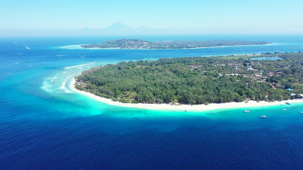 Aerial panorama of tranquil lagoon beach lifestyle by blue sea and bright sandy background of a dayo