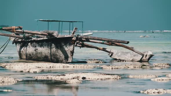 Old Dry African Fishing Rowboat Stranded in Sand on Beach at Low Tide Zanzibar