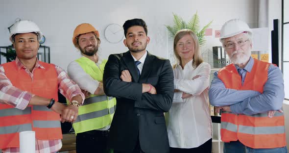 Team of Architects with Successful Bearded Main Architect which Posing on Camera with Crossed Arms