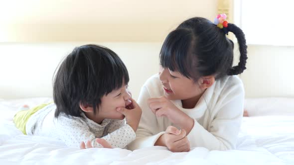 Cute Asian Children Playing On White Bed