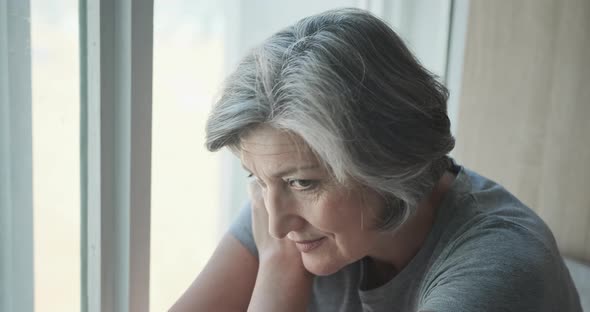 A Pensive Elderly Woman in a Rehab Center Sits By the Window