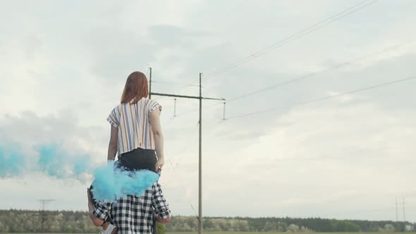 Woman with Smoke Bomb Sitting on Man's Shoulders