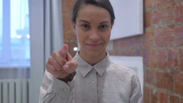 Serious Hispanic Woman Pointing at Camera with Finger