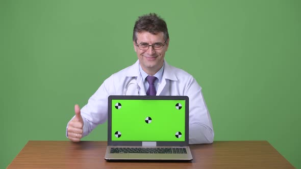 Mature Handsome Man Doctor Against Green Background