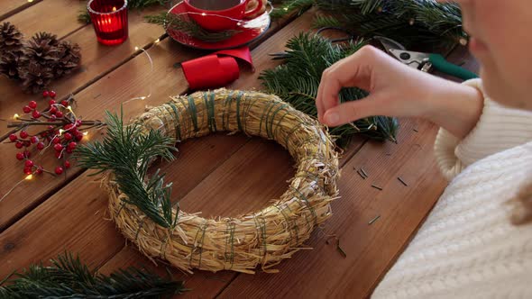 Woman Making Fir Christmas Wreath at Home