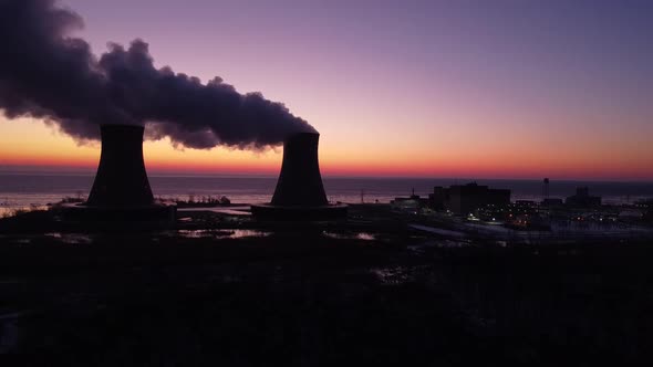 Static Shot - Aerial Drone footage of a Nuclear Power Plant Cooling Towers are Sunrise with steam Wi