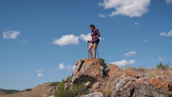 Happy Woman Climbs To Top Mountain And Raises His Arms Up Celebrating Success