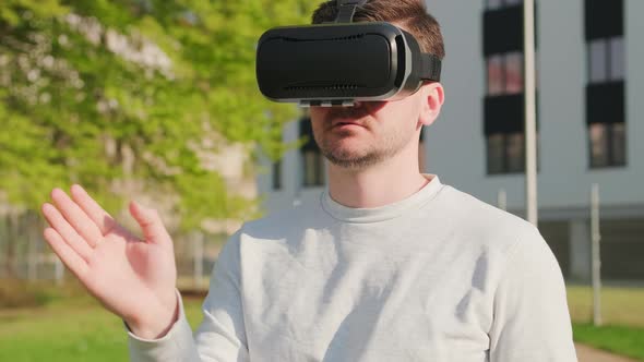 Man Wearing Virtual Reality Headset and Manage the Interface in Augmented Reality