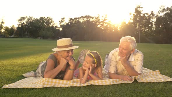 Seniors and Granddaughter Having Rest in Park.