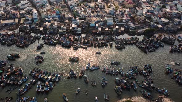 Vietnamese city buildings and many fishing boats moored on river coast