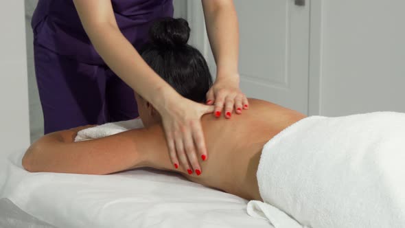 Professional Masseuse Massaging Back and Shoulders of a Client