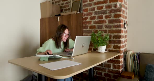 Woman in Mask Working at Night Using Laptop