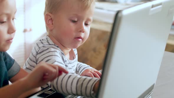 Little Brother and Sister Playing on Laptop