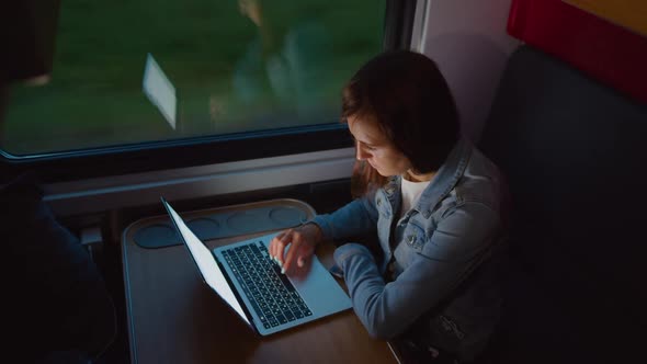 Woman Using Laptop in Moving Train