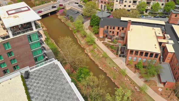 Aerial drone shot of city buildings, bridge, and river.