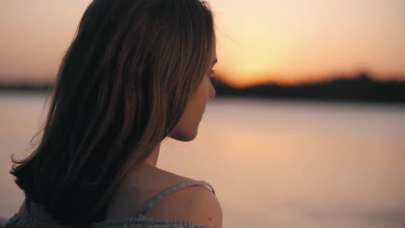 the Girl Came to the Embankment of the River and Looks at the Sunset