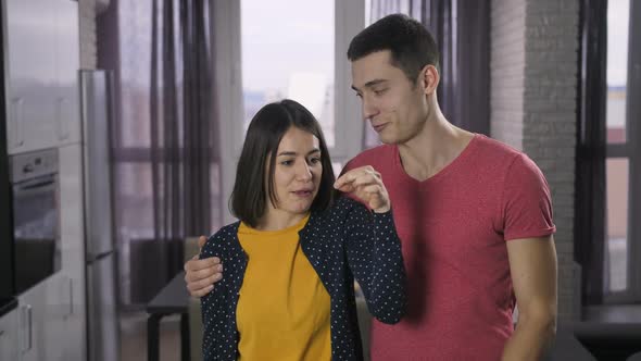 Young Couple Showing New Home Keys To Camera