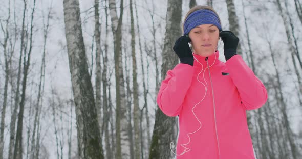 A Young Girl on the Morning Jog Holds in Her Hands a Smartphone Picks a Music Track for Training