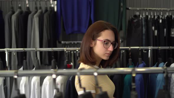 Young Woman Chooses Clothes in the Store. Clothing Store.