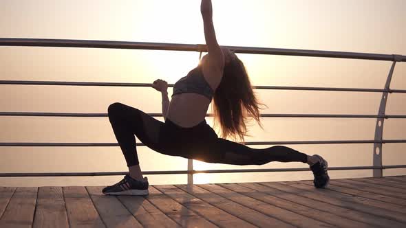 Longhaired Girl in Sportswear Stretches the Muscles of the Legs Makes Lunges