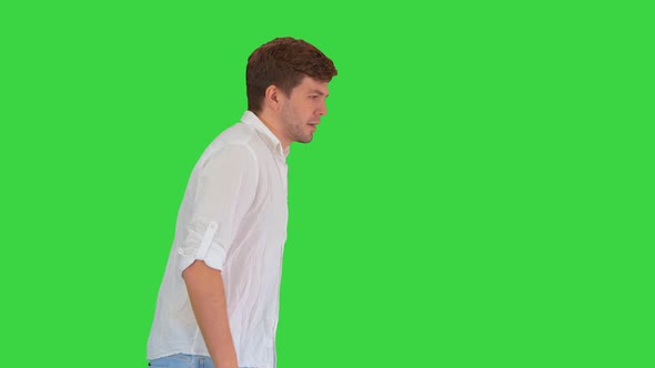 Exhausted Young Man Suffering From Heat While Walking on a Green Screen, Chroma Key