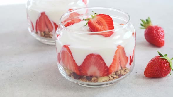 Strawberry parfait with yogurt and granola in glass jar. Healthy breakfast recipe.