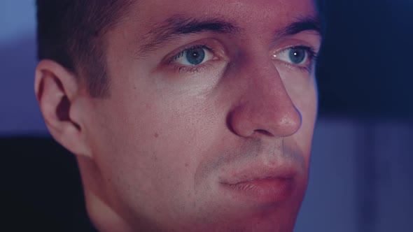 Close Up Young Man Watching a Horror Video or Film on TV or a Computer Monitor at Home