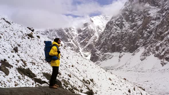 Tourist on Mountain Top. Sport and Active Life. Hiker with Backpack Standing on Top of a Mountain