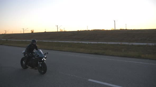 Man in Helmet Riding on Modern Sport Motorbike at Evening Highway. Motorcyclist Racing His
