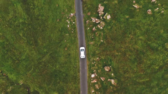 Aerial Top View of Generic Electric Car Driving on Country Road in Faroe Islands