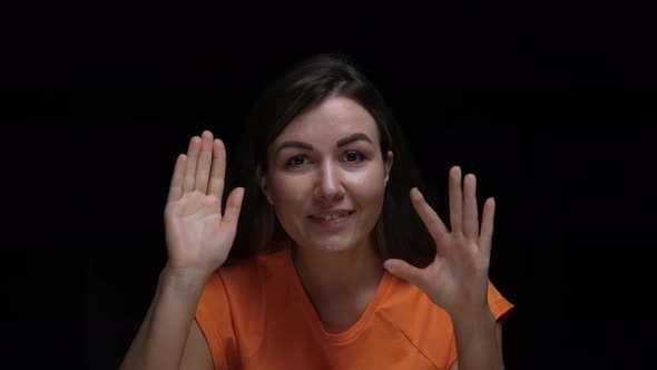 Portrait of an Excited Young Girl Banging Her Fists and Palms on the Glass Waving Hello and