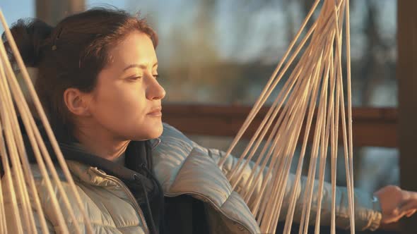 A Young Woman on the Balcony is Drinking a Cup of Coffee or Tea Admiring the Sunset