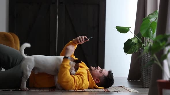 man trying to do sports exercises next to a dog at home on the floor