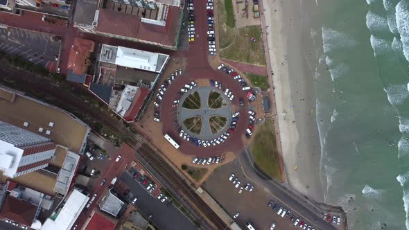 Birds eye drone shot of Muizenberg, Cape Town - drone is descending over the famous Surfers Corner.