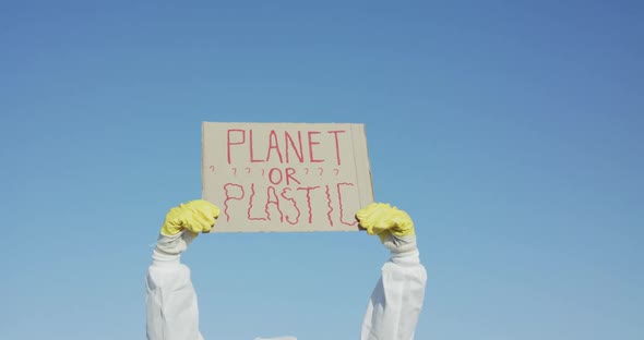 Raised By Hands Protest Sign Planet or Plastic on Sky Background