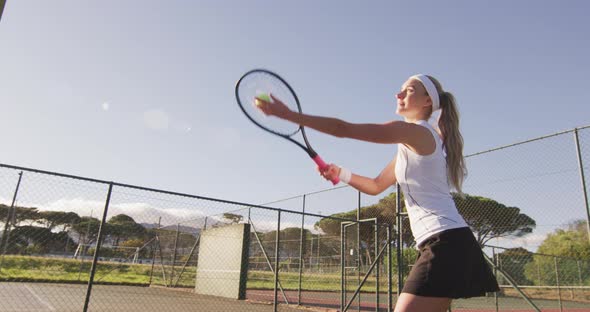 Video of happy caucasian female tennis player holding racket and hitting ball