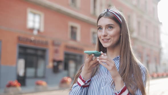 Young Pretty Stylish Girl with Brown Hair and Headband on It Wearing Striped Dress Using Her