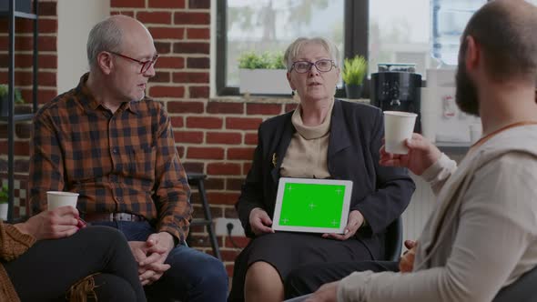 Therapist Holding Tablet with Horizontal Green Screen at Aa Meeting with People