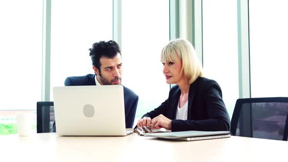 Two Business People Talk Project Strategy at Office