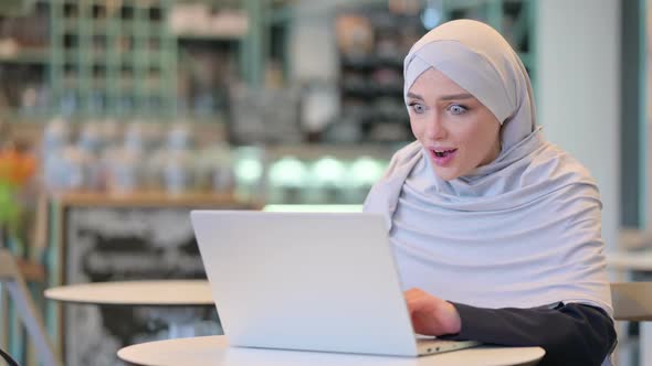 Beautiful Arab Woman Celebrating Success on Laptop